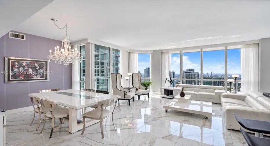 Expansive living area with large floor-to-ceiling windows, polished marble-look flooring, and a crystal chandelier