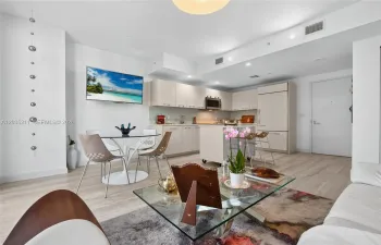 Light-toned cabinetry, kitchen island, built-in stainless steel appliances, and wood-finish flooring