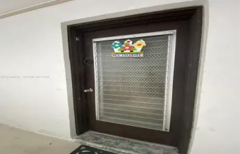 Dark-toned solid core entry door featuring a full-length metal security screen insert and integrated round-knob hardware