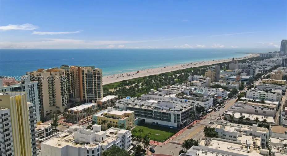 Aerial perspective featuring coastal shoreline, ocean horizon, and urban cityscape