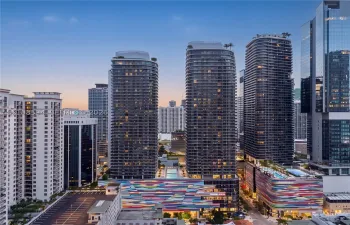 High-rise residential towers featuring floor-to-ceiling glass facades, wrap-around balconies, rooftop landscaping, and integrated multi-level parking structures