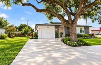 Exterior featuring a concrete driveway, attached garage, mature landscaping, and horizontal siding accents