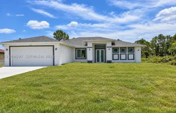 Stucco exterior featuring a dual-car garage, recessed entryway with a glass-paneled front door, transom window, and architectural shingle roofing