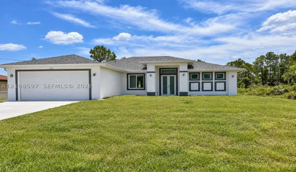Stucco exterior featuring a dual-car garage, recessed entryway with a glass-paneled front door, transom window, and architectural shingle roofing