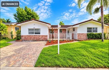 Single-story exterior featuring a brick and stucco facade, decorative tile roof, paved driveway, and white metal front railing