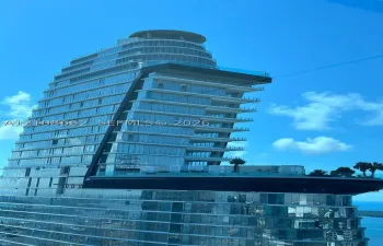 Contemporary high-rise architecture featuring a glass curtain wall, cantilevered design, multi-level terraces, and integrated rooftop landscape elements