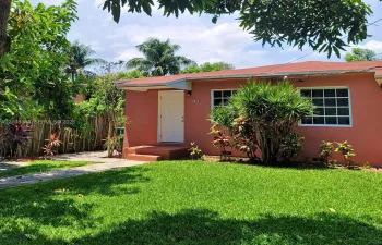 Charming duplex residence with a single-family-home feel, gated entrance, and spacious front yard.