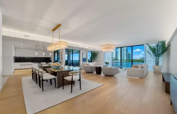 Open-concept living space featuring wood-finish flooring, floor-to-ceiling windows, recessed lighting, and a modern linear chandelier