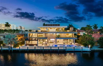 Three-story modern waterfront residence featuring a private boat dock, multi-level terraces with glass railings, stone veneer accents, and a rectangular swimming pool