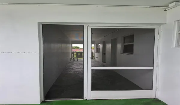 White aluminum frame screen door featuring a glass-inset panel and secure latch hardware