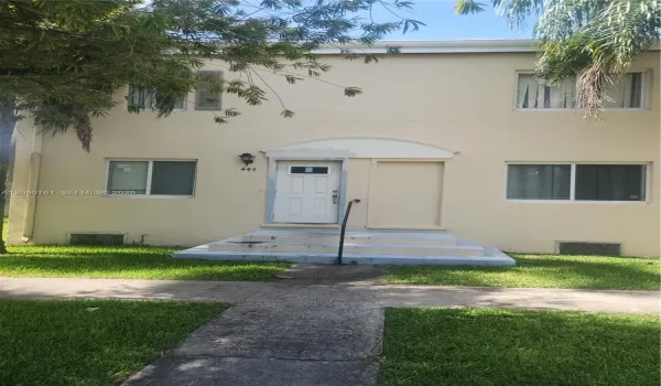 Two-story exterior featuring a smooth stucco facade, concrete entry steps with a metal handrail, and multi-pane windows