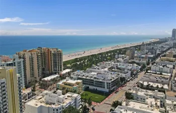 Aerial perspective featuring coastal shoreline, ocean horizon, and urban cityscape