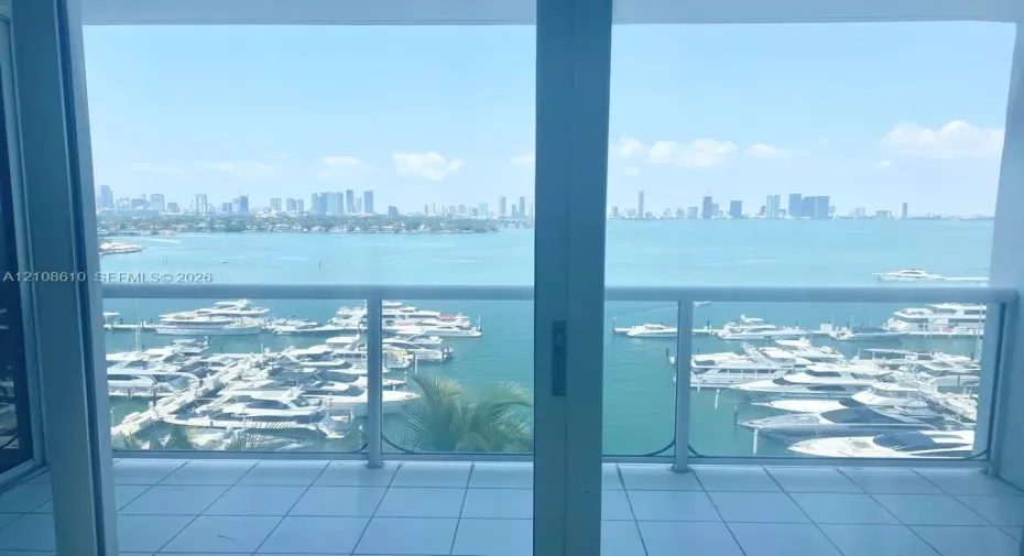 Balcony featuring ceramic tile flooring, a white metal frame, and glass panel railing