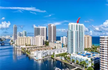 High-rise building featuring private balconies, floor-to-ceiling windows, and a waterfront location