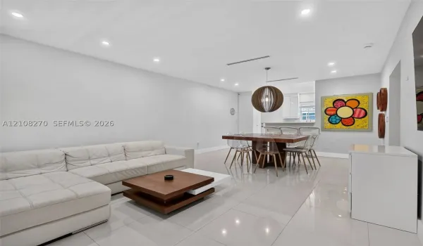 Open-concept interior featuring large-format tile flooring, recessed lighting, and a spherical wood-slat pendant fixture