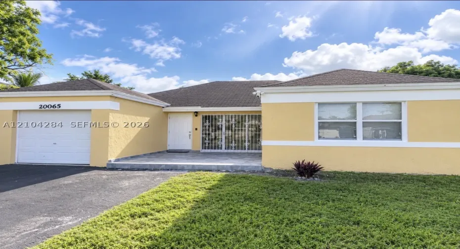 Stucco exterior with contrasting white trim, single-car garage, covered entryway, and stone-finished porch