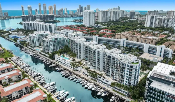 Aerial perspective featuring waterfront residential buildings, deep-water canal boat slips, and an expansive cityscape backdrop