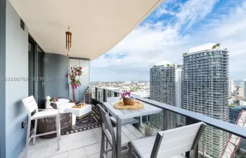 Covered balcony featuring tile flooring and a glass-paneled railing