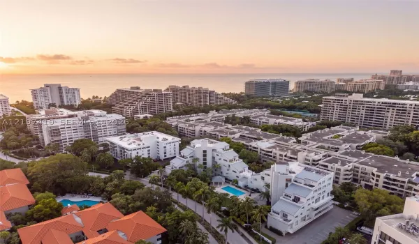 Aerial perspective showcasing dense tropical landscaping, multiple swimming pools, and proximity to the coastline