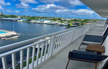 Private balcony featuring a white metal railing and a direct outlook over the waterway and surrounding coastal landscape