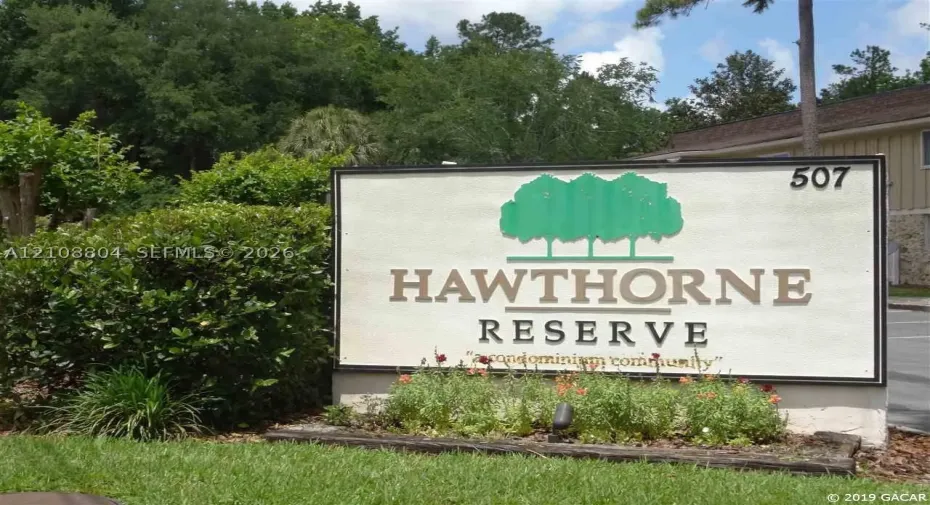Freestanding Hawthorne Reserve monument signage featuring professional lettering, integrated landscape bed, and mature evergreen plantings