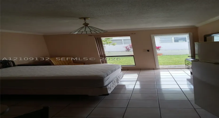 Ceramic tile flooring, crown molding, a hanging geometric pendant light, a floor-to-ceiling window, and a glass-paneled exterior door