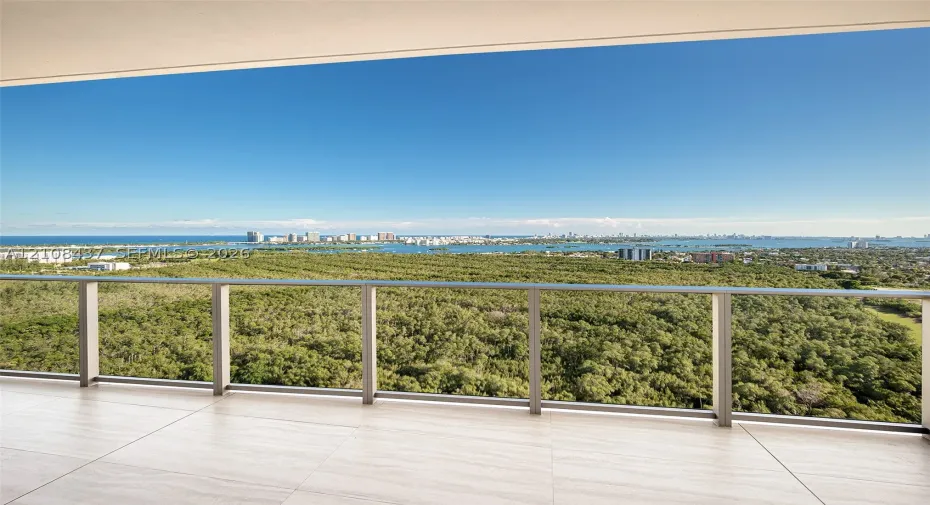 Covered balcony featuring large-format stone-finish tile flooring and a minimalist metal railing