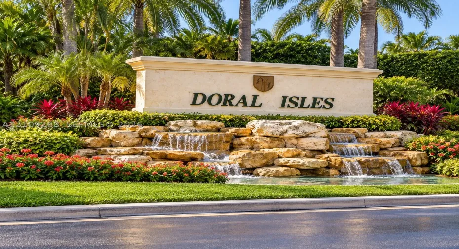 Community monument sign featuring multi-tiered natural stone water features, integrated landscaping, and mature palm trees