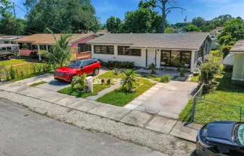 Single-story residence featuring a neutral exterior, multi-pane windows, asphalt shingle roof, concrete driveway, and a paved walkway