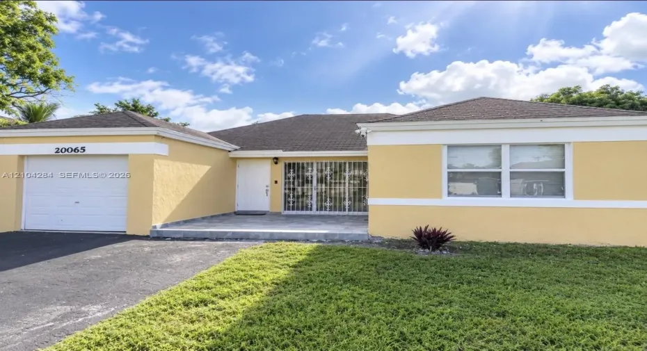 Stucco exterior with contrasting white trim, single-car garage, covered entryway, and stone-finished porch