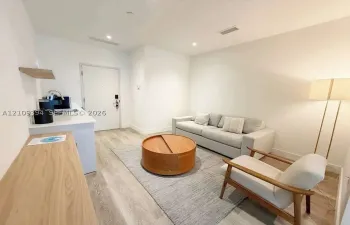 Built-in kitchenette featuring a stone-composite countertop, stainless steel sink, and wood-finish cabinetry