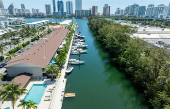 Waterfront property featuring a canal-side dock, rectangular swimming pool, and concrete paved pool deck