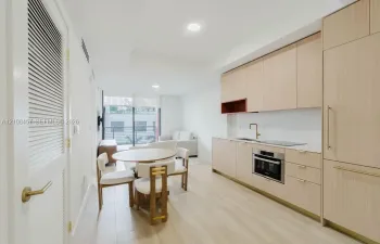Kitchen featuring light wood-finish cabinetry, quartz countertops, an integrated refrigerator, recessed lighting, and wood-finish flooring