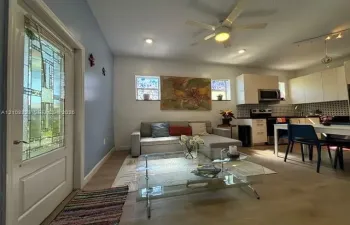 Entry door with decorative glass inlay, wood-finish flooring, recessed lighting, ceiling fan, and white cabinetry