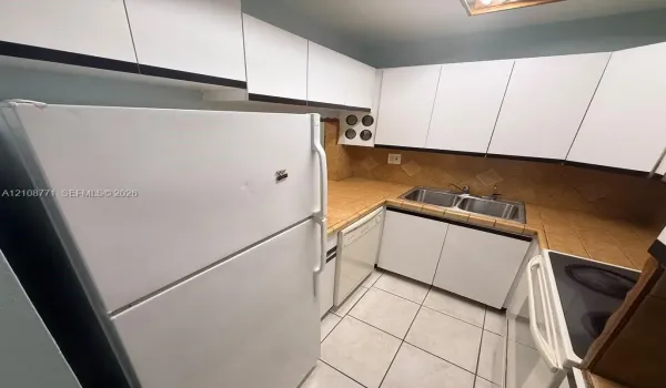 Kitchen featuring white cabinetry, tile countertops, tile backsplash, tile flooring, and a stainless steel double-basin sink