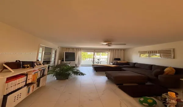Large-format tile flooring, ceiling fan, and sliding glass doors providing external access