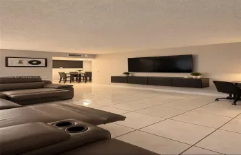 Neutral-toned ceramic tile flooring, wall-mounted dark cabinetry, and a textured ceiling finish