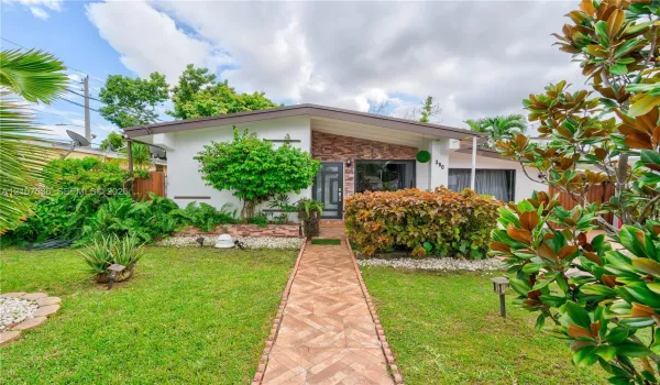 Mid-century modern architectural style featuring a low-pitched roofline, stone veneer facade accent, and a dedicated herringbone-patterned paved walkway
