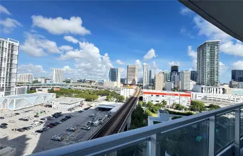 Private balcony featuring a glass panel railing and an expansive urban skyline panorama