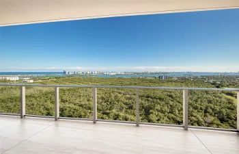 Covered balcony featuring large-format stone-finish tile flooring and a minimalist metal railing