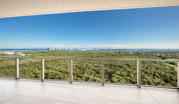 Covered balcony featuring large-format stone-finish tile flooring and a minimalist metal railing