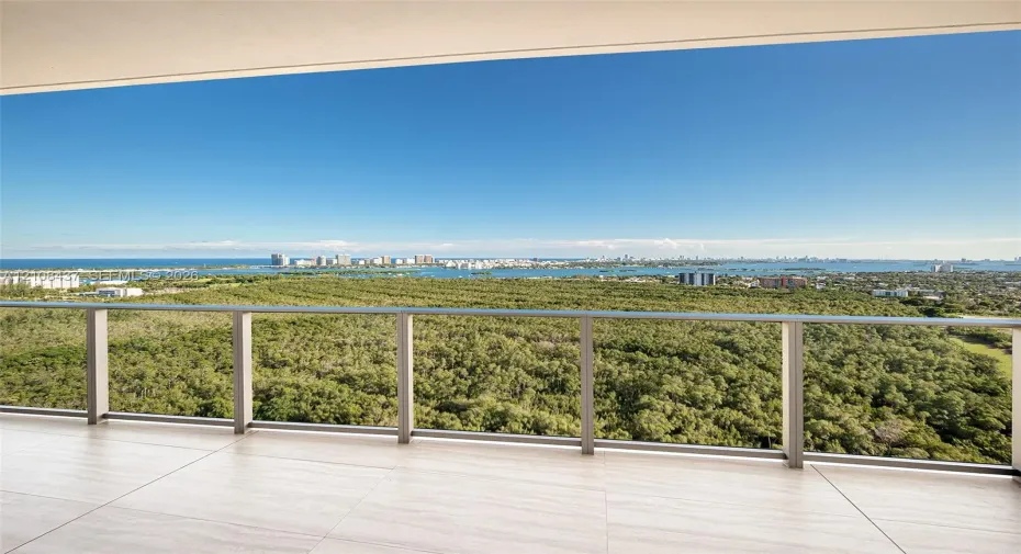 Covered balcony featuring large-format stone-finish tile flooring and a minimalist metal railing