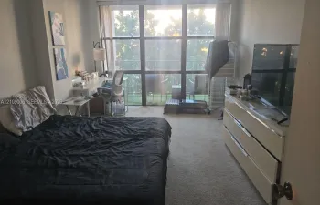 Floor-to-ceiling windows featuring balcony access and neutral carpeting