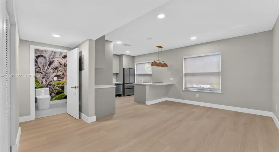 Kitchen featuring wood-finish flooring, recessed lighting, a breakfast bar, and stainless steel appliances
