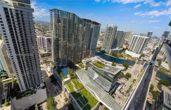High-rise perspective featuring an outdoor swimming pool, landscaped green roofs, glass-facade architecture, and water frontage