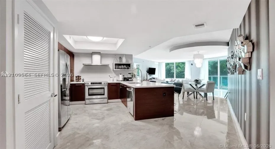 Kitchen featuring dark wood-finish cabinetry, quartz countertops, stainless steel appliances, recessed lighting, and tile flooring