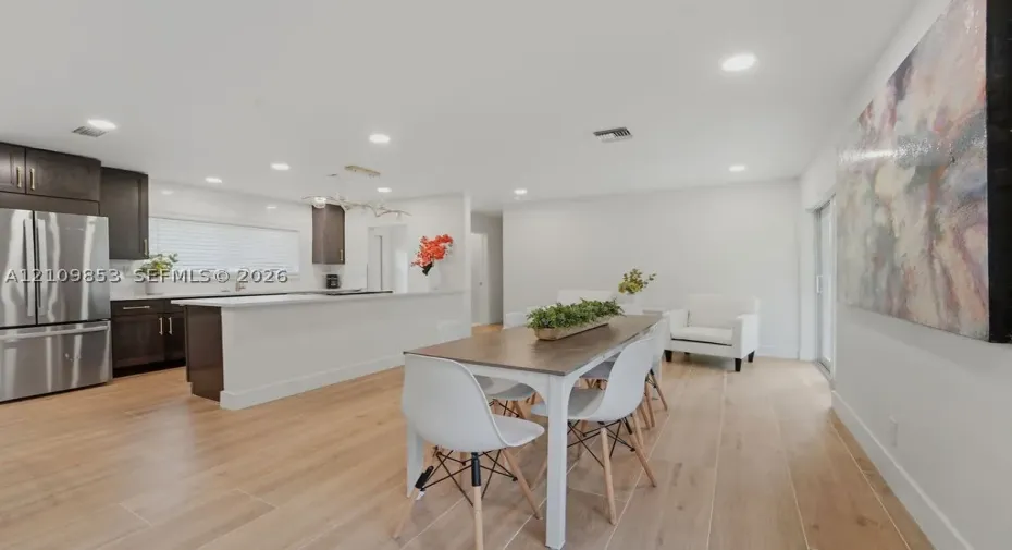 Kitchen featuring dark-finish cabinetry, a peninsula counter, stainless steel appliances, and recessed lighting, complemented by wood-finish flooring throughout the space