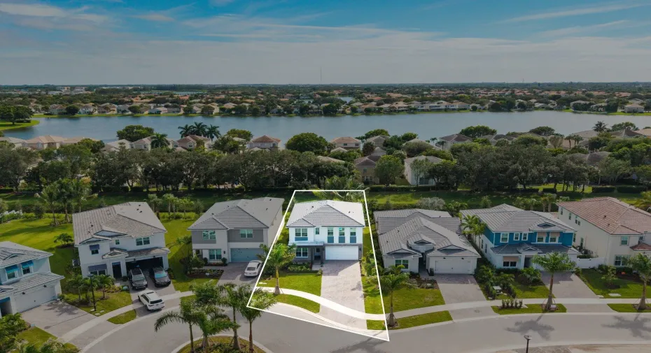 Two-story residence featuring a tile roof, paver driveway, attached two-car garage, and a waterfront lot location