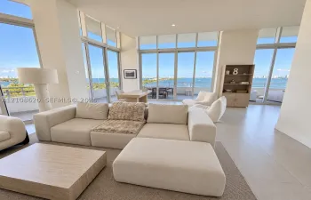 Open-concept living space featuring floor-to-ceiling windows, porcelain tile flooring, recessed lighting, and multiple sliding glass doors leading to private balconies