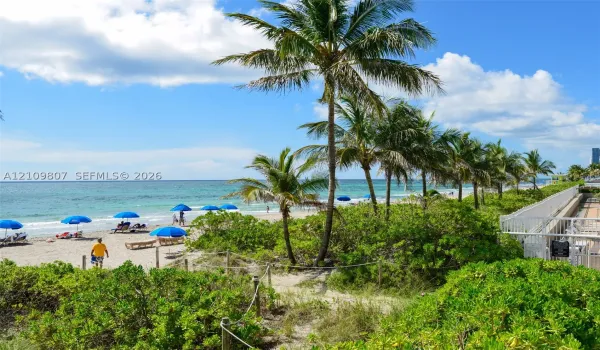 Direct access to sandy beach, perimeter security fencing, and mature tropical landscaping